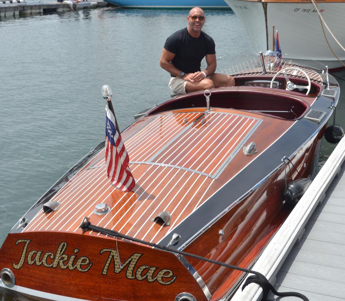 Corey Glass sits aboard his 1938 19-foot Chris-Craft, Jackie Mae, during the Newport Beach Club Wooden Boat Festival.