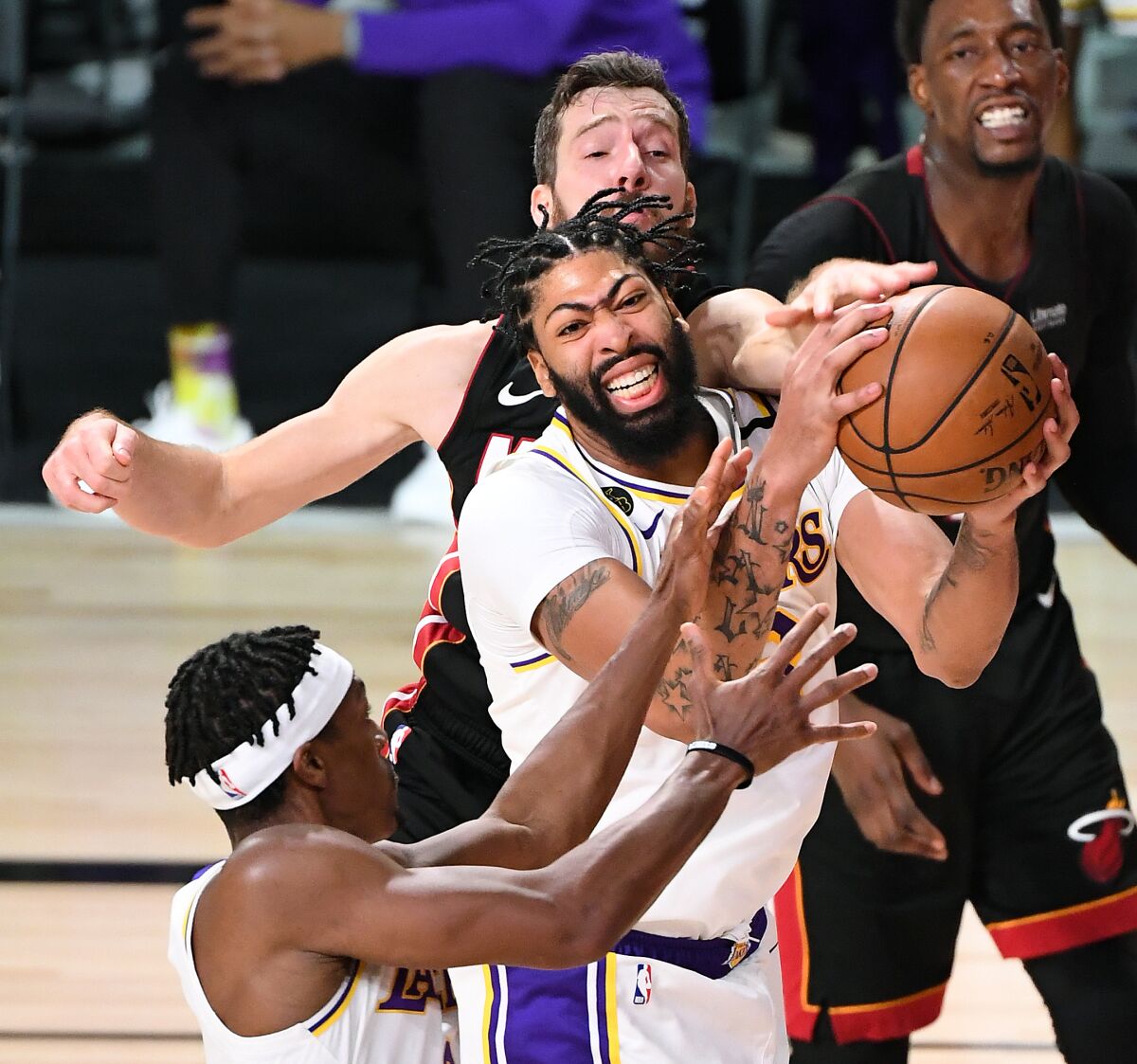 Lakers Anthony Davis grabs a rebound form Heat's Goran Dragic.