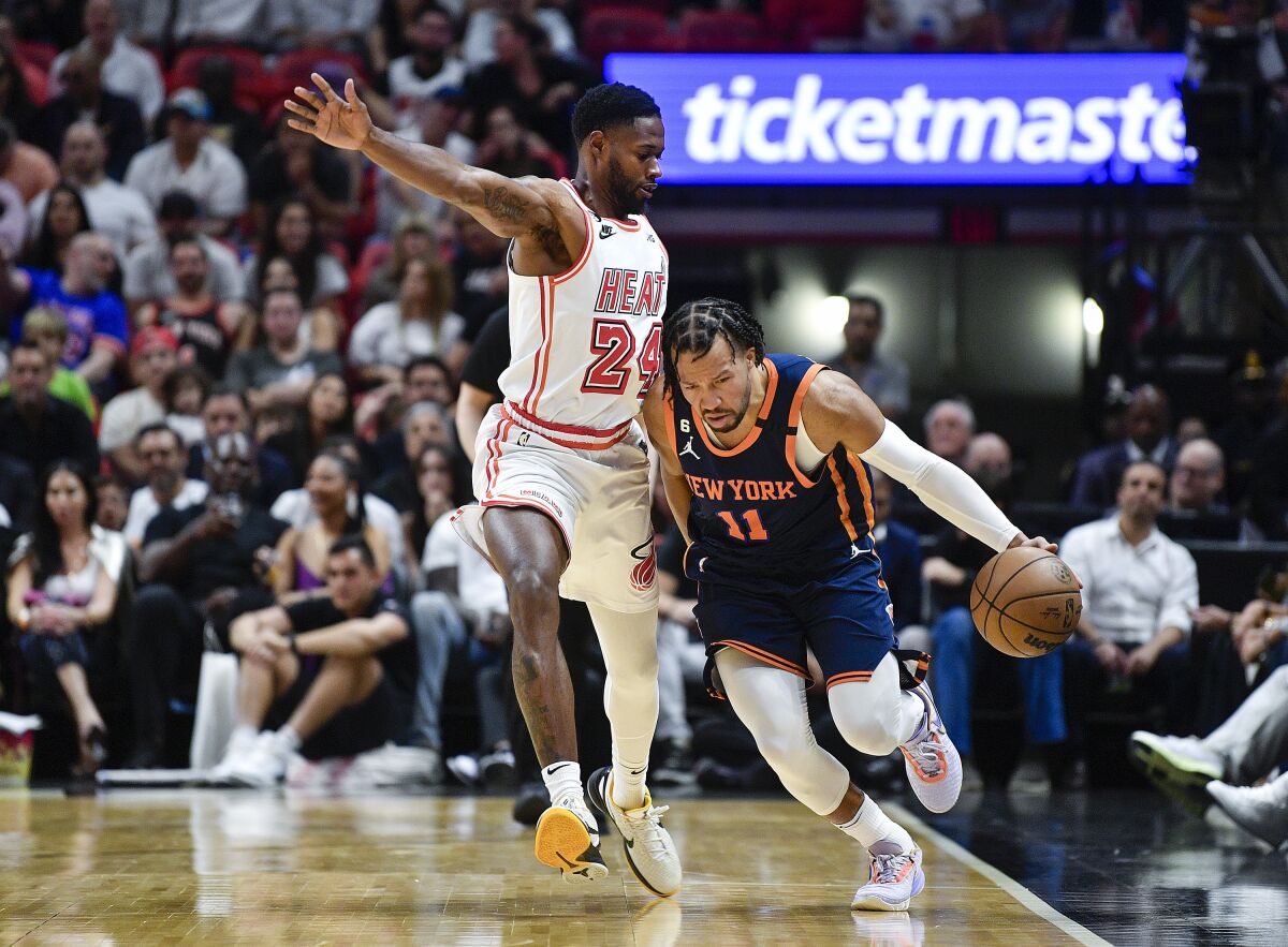 New York Knicks guard Jalen Brunson (11) dribbles the ball while being guarded by Miami Heat forward Haywood Highsmith (24) during the first half of an NBA basketball game, Wednesday, March 22, 2023, in Miami, Fla. (AP Photo/Michael Laughlin)