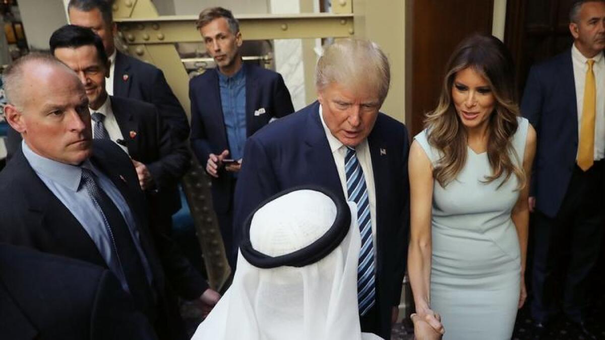 Donald and Melania Trump greet a guest at a grand-opening ceremony last month at Trump's new hotel in Washington.