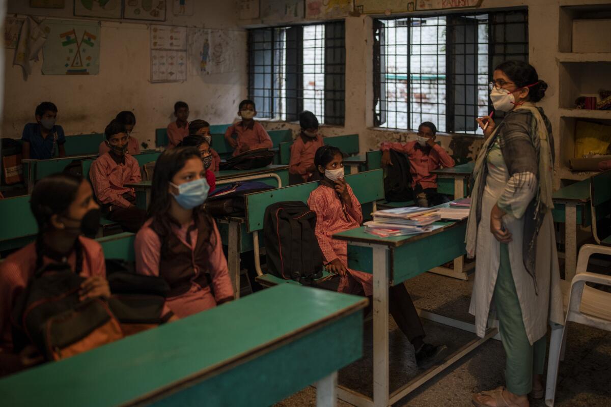 Students attend a class on the first day of partial reopening of schools in Noida, a suburb of New Delhi, India, Wednesday, Sept. 1, 2021. Many students in India will be able to step inside a classroom for the first time in nearly 18 months from Wednesday, as authorities have given the green light to partially reopen schools despite apprehension from some parents and signs that coronavirus infections are picking up again. Schools and colleges in least six states will reopen in a gradual manner with health measures in place throughout September. In New Delhi, all staff must be vaccinated and class sizes will be capped at 50% with staggered seating and sanitized desks. (AP Photo/Altaf Qadri)