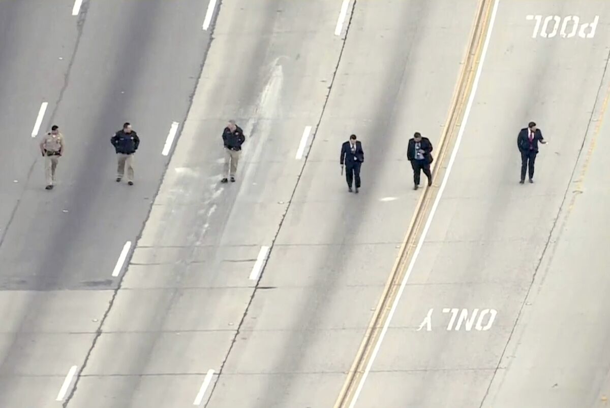 CHP officers walk on the freeway