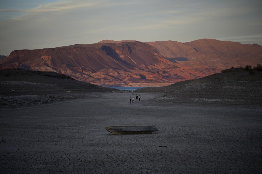 A formally sunken boat sits on cracked earth hundreds of feet from what is now the shoreline on Lake Mead.