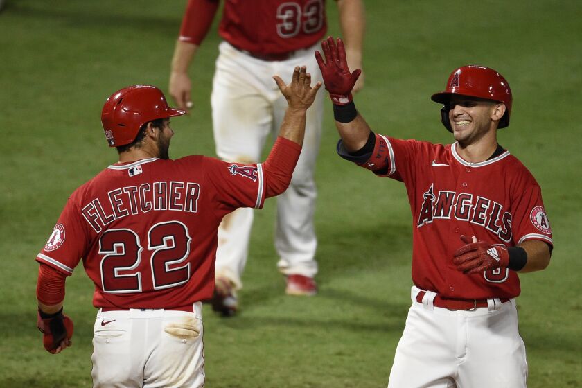 The Angels' Tommy La Stella, right, celebrates with David Fletcher after hitting a walk-off, two-run home run Aug. 17, 2020.