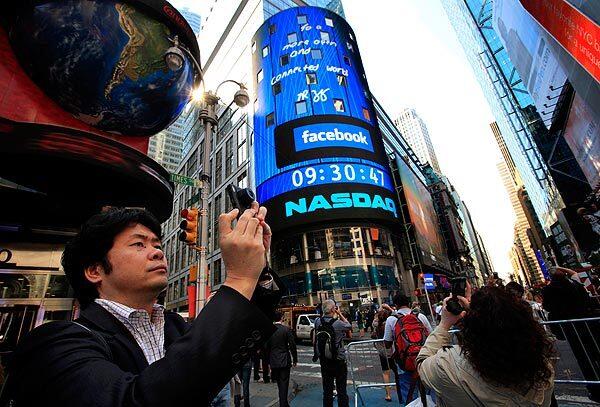 Facebook is listed on the Nasdaq stock exchange shown on the board in Times Square in New York.