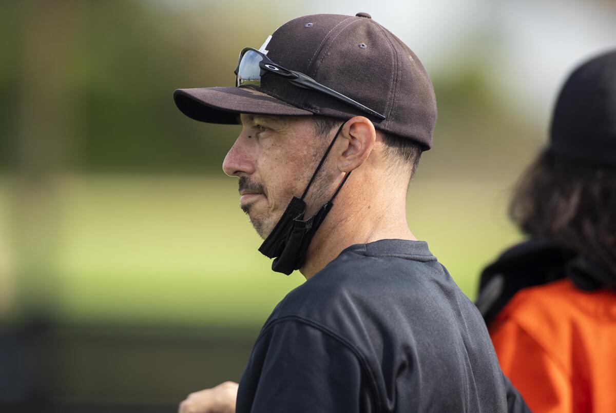 Aaron Pines coaches from the dugout during a Garden Grove League baseball game against his brother Greg Pines on May 17.