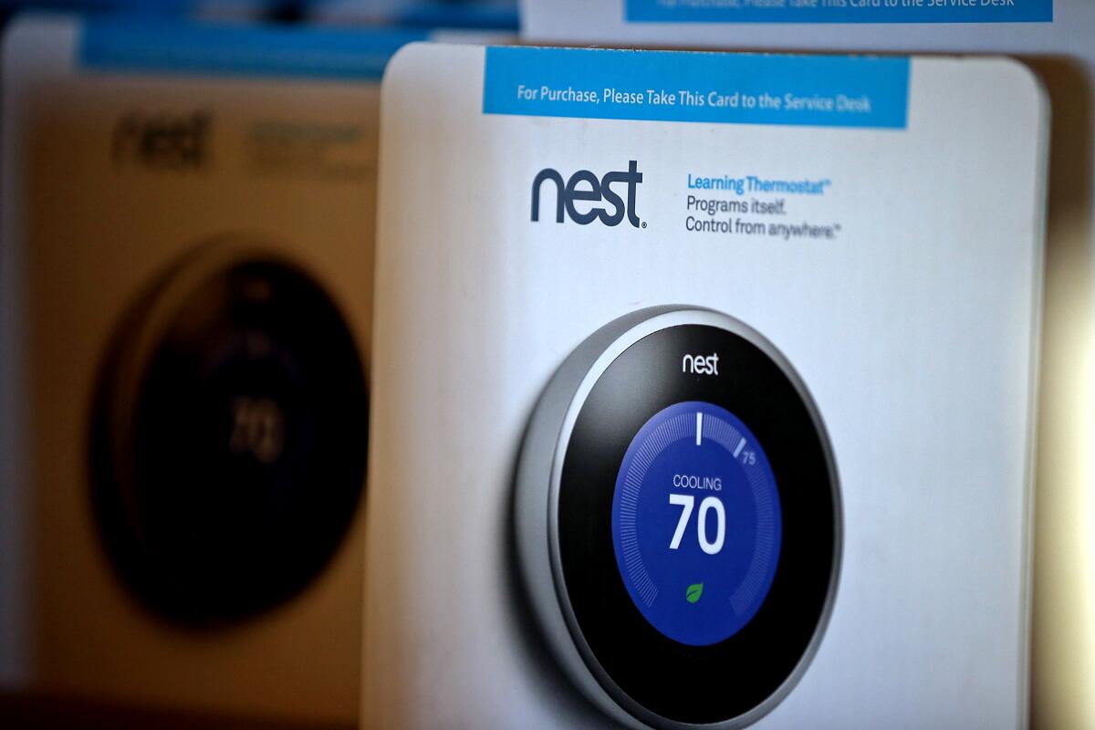 Two packaged Nest Learning Thermostats are displayed at a store.