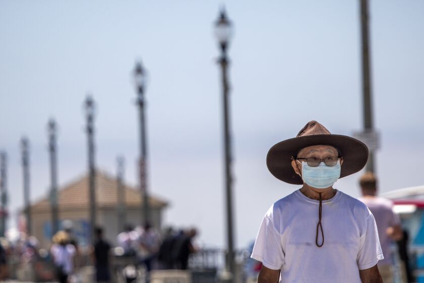 A man wears a mask in Huntington Beach. (Allen J. Schaben / Los Angeles Times)