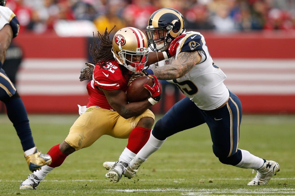 The Rams' James Laurinaitis tries to stop San Francisco's DuJuan Harris during Laurinaitis' last game with the Rams, on Jan. 3, 2016.