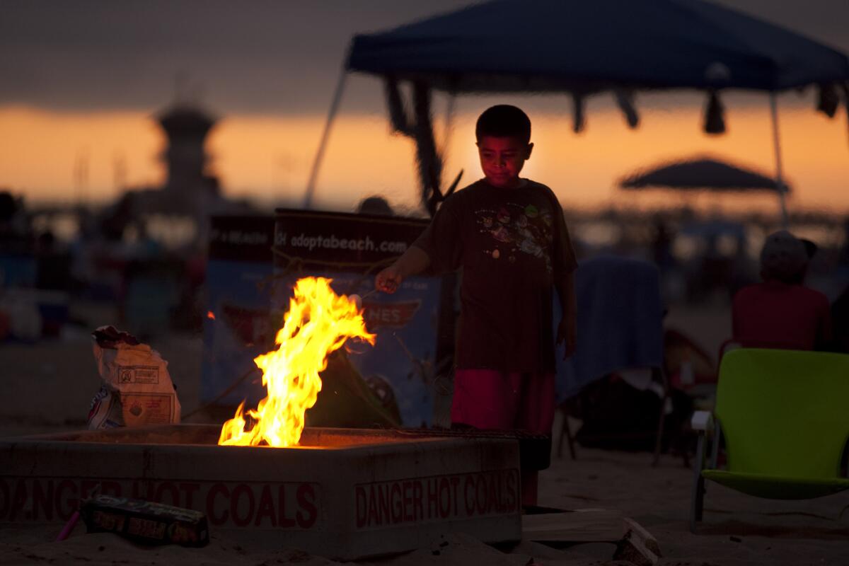 A young boy roasts marshmallows over a fire ring during last year's Fourth of July holiday.