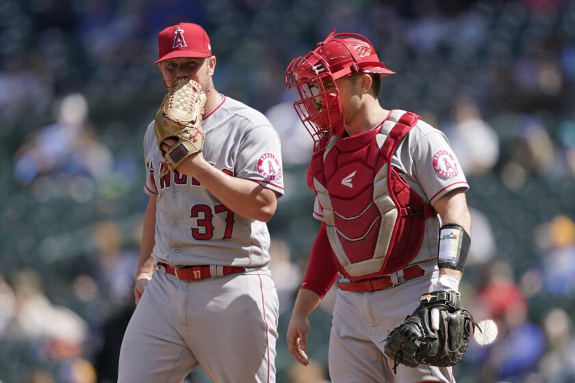 Los Angeles Angels starting pitcher Dylan Bundy, left, talks with catcher Max Stassi on the mound during the fourth inning of a baseball game against the Seattle Mariners, Sunday, May 2, 2021, in Seattle. (AP Photo/Ted S. Warren)