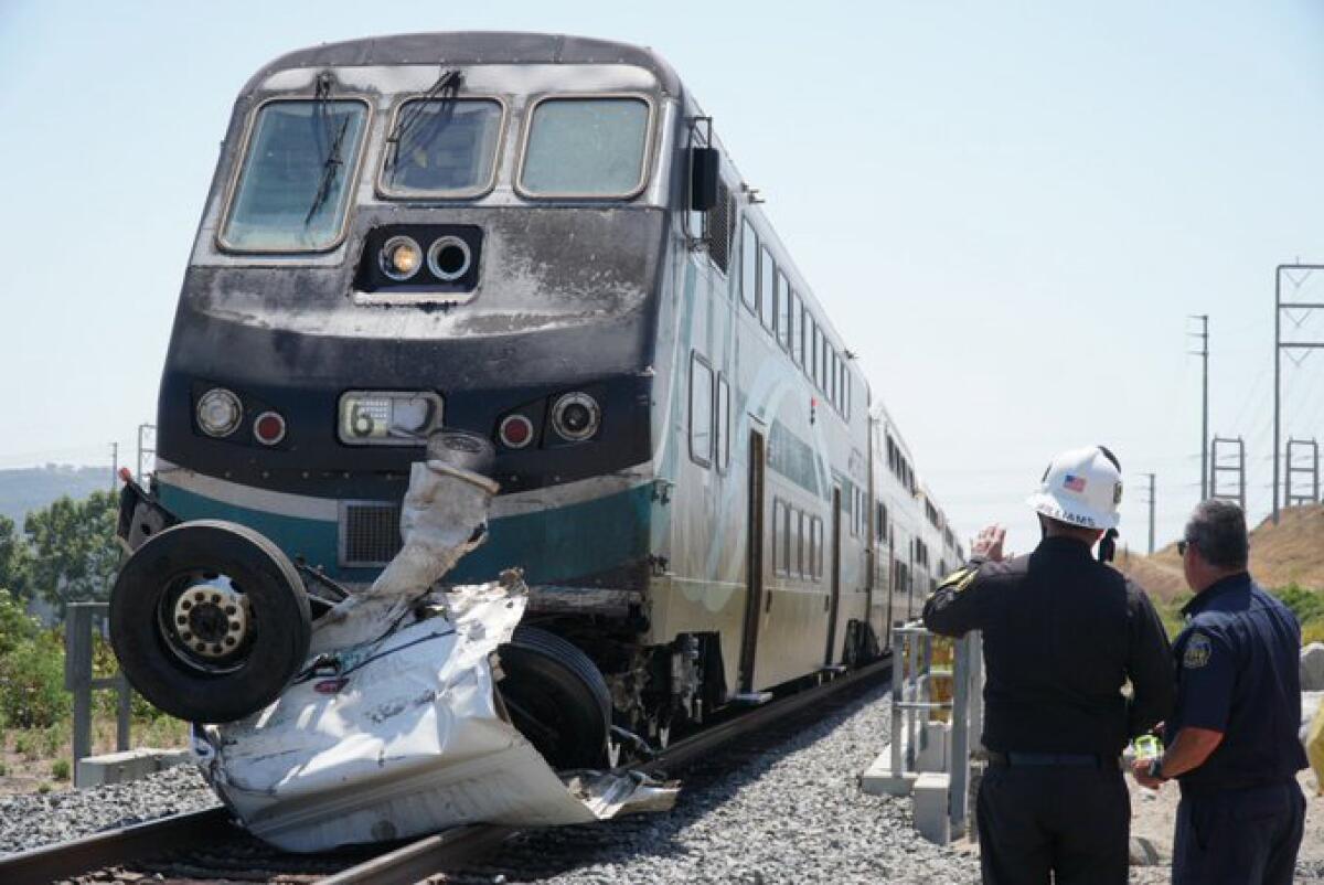Wreckage of a truck is seen against the front of a commuter train.