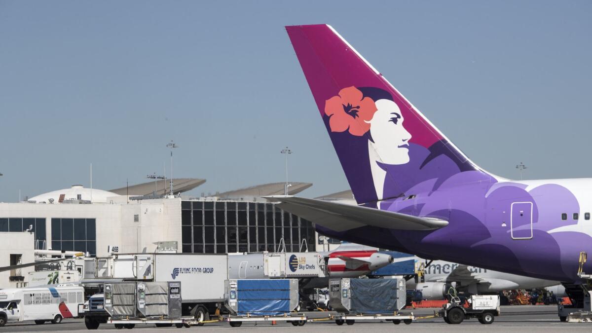 A Hawaiian Airlines aircraft waits on the tarmac at Los Angeles International Airport on March 28, 2018. The carrier raised fees by $5, to $30 for the first checked bag and $40 for the second.