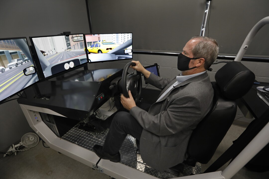 Thomas D. Marcotte demonstrates a driving simulator used to test the effect of cannabis on users.