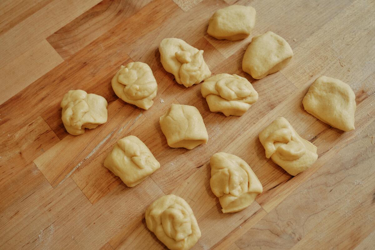 A dozen dough pieces for the pan de muerto, two apiece, for making crisscrossing "bones."