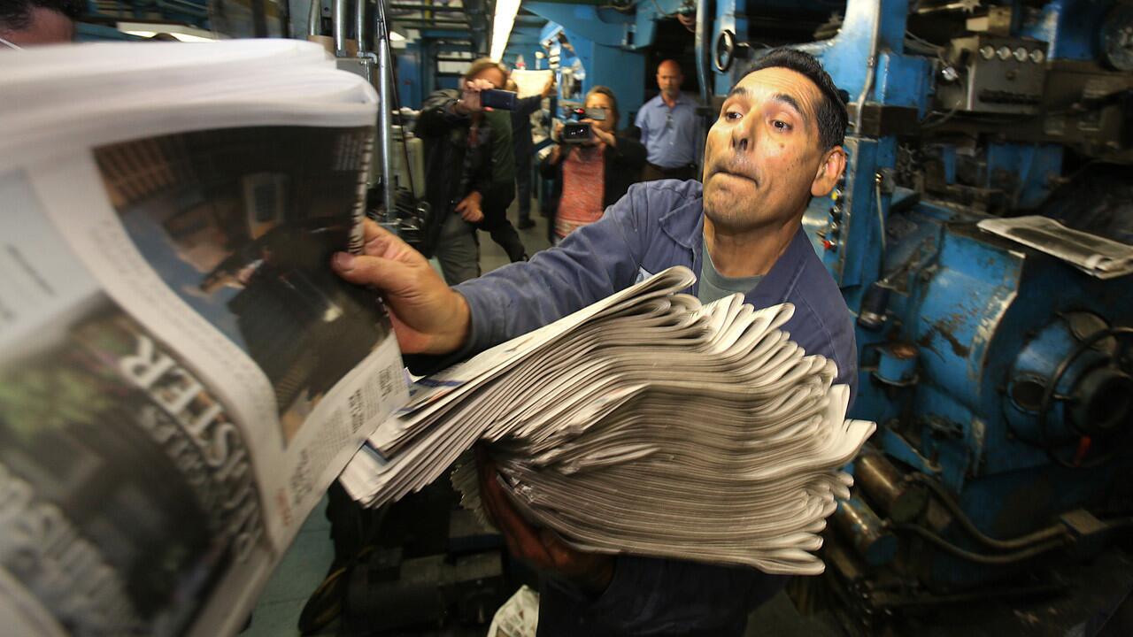Pressmen check the first copies of the Los Angeles Register's inaugural edition on April 16 in Santa Ana.
