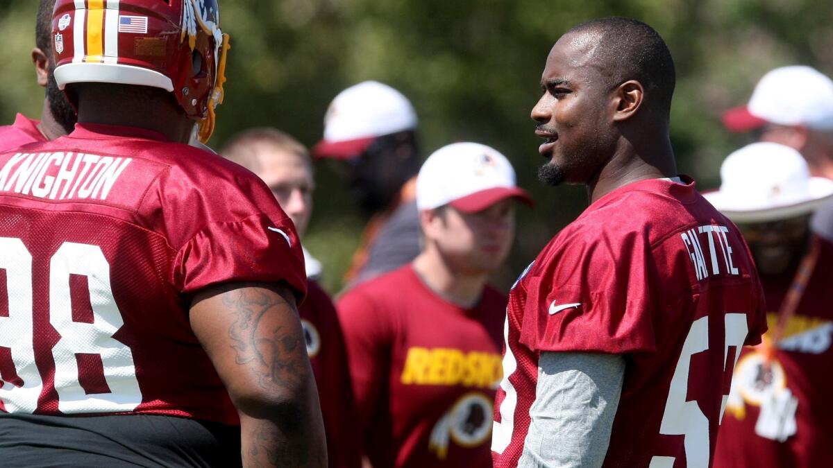Redskins linebacker Junior Galette, right, talks to defensive tackle Terrance Knighton and another teammate during training camp.