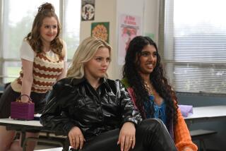 Three teenage girls sit at a high-school lunch table.
