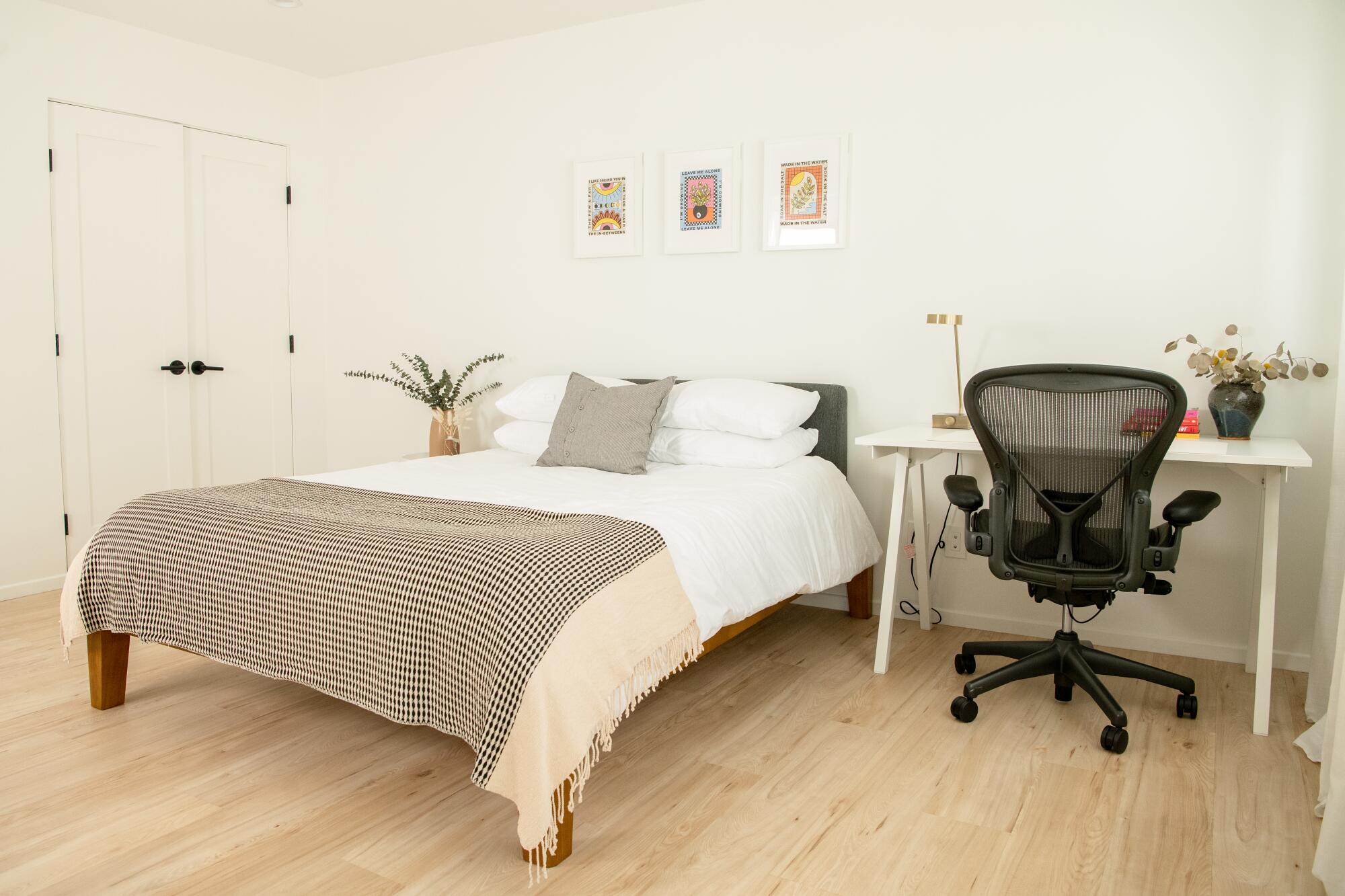A queen bed sits between side-by-side closets and a desk in the ADU's bedroom.