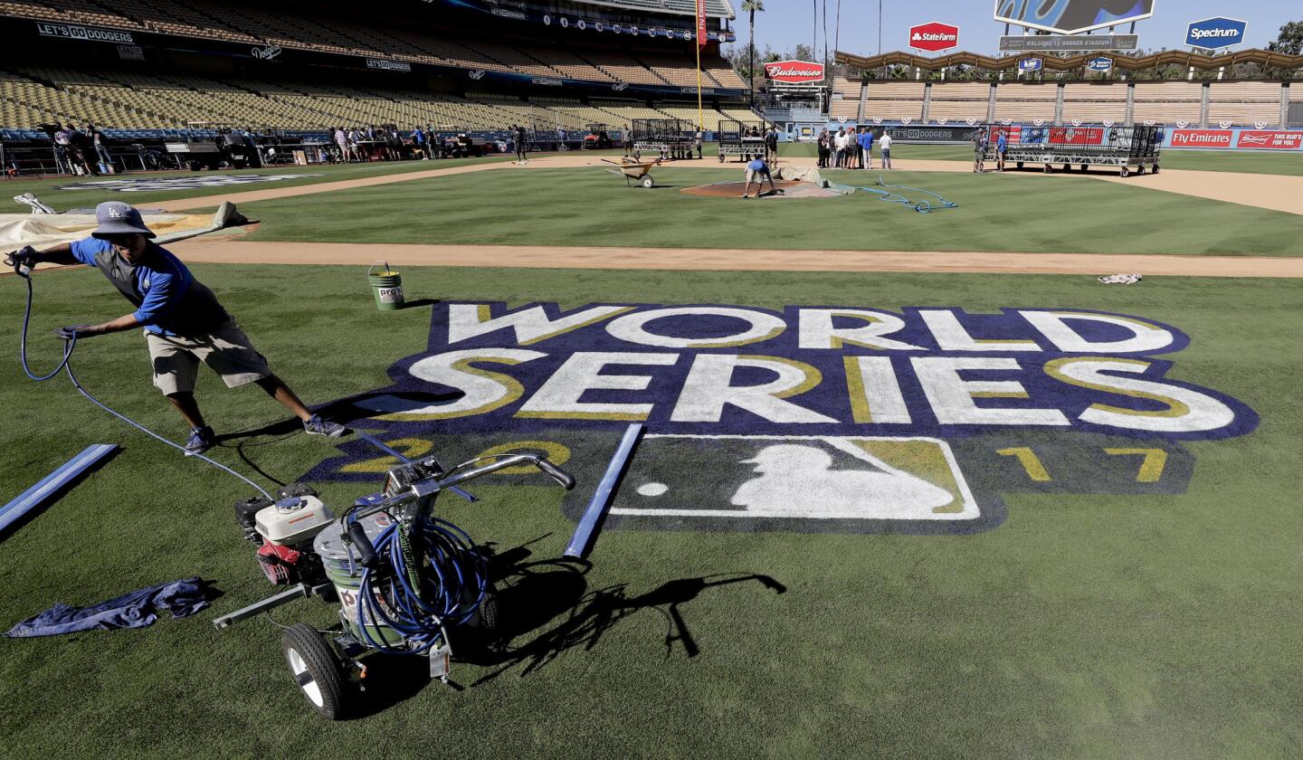 Oscar Del Real pule los últimos detalles en el logo de la Serie Mundial en el terreno del Dodger Stadium.