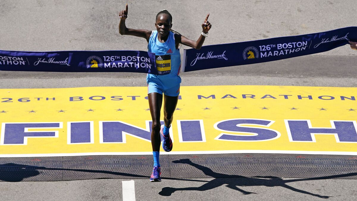 FILE - Peres Jepchirchir, of Kenya, breaks the tape to win the women's division of the Boston Marathon, Monday, April 18, 2022, in Boston. Tokyo Olympic gold medalist Jepchirchir plans to defend her title at the New York City Marathon, telling The Associated Press she hopes to break the course record this November after finishing 8 seconds off the mark last year. Jepchirchir won the Olympic and NYC marathons four months apart in 2021, then won this spring’s Boston Marathon. She is the first athlete — male or female — to win all three events. (AP Photo/Charles Krupa, File)
