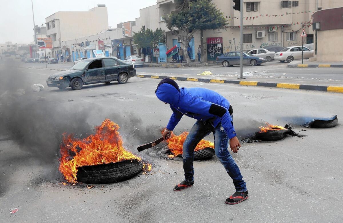 A protester sets tires ablaze during a demonstration last month in Tripoli, Libya.