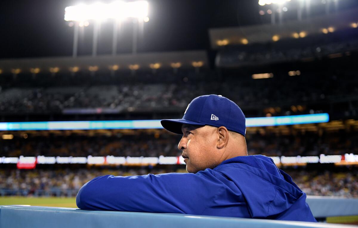 Dodgers manager Dave Roberts looks on from the dugout at Dodger Stadium.