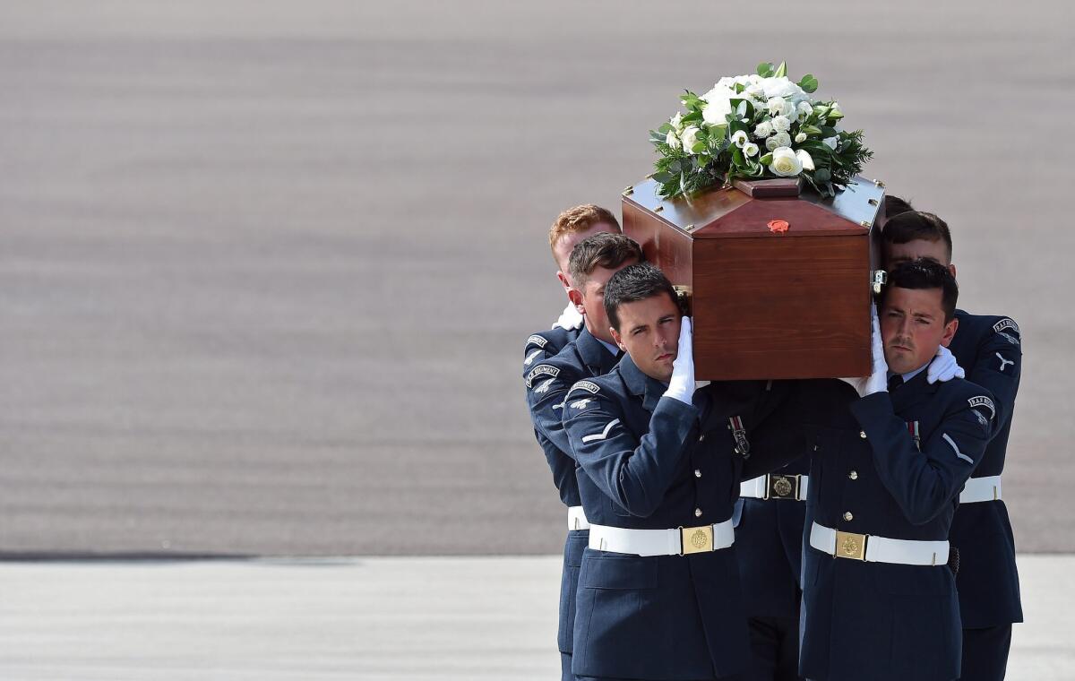 The coffin of Christopher Dyer is carried in Brize Norton, England, on Friday after arriving on a Royal Air Force plane that repatriated the bodies of five British nationals killed in a terrorist attack in Tunisia on June 26.