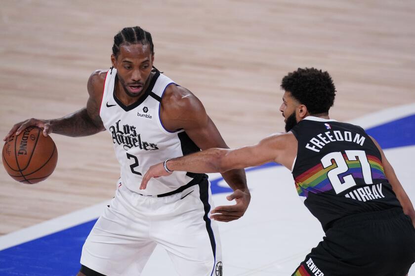 Los Angeles Clippers' Kawhi Leonard (2) tries to get past Denver Nuggets' Jamal Murray (27) during the first half of an NBA conference semifinal playoff basketball game Monday, Sept. 7, 2020, in Lake Buena Vista, Fla. (AP Photo/Mark J. Terrill)