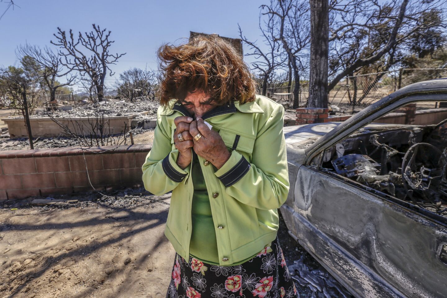 Mabel Ramos, 73, is overcome by emotion upon seeing the devastation caused by the Blue Cut fire, which swept through her Oak Hills residence.