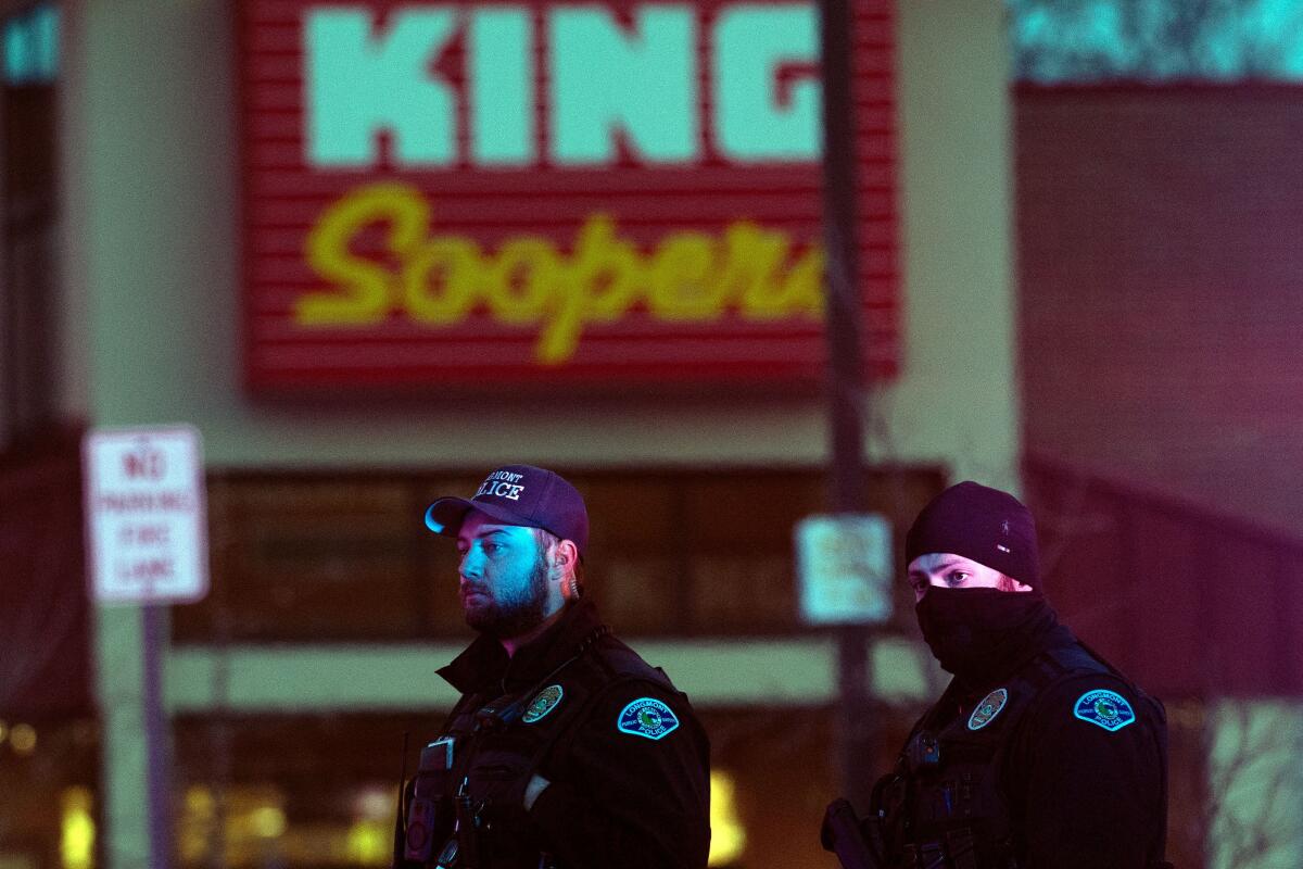 Police officers keep watch in the parking lot of the King Soopers grocery store in Boulder, Colo., on Monday.