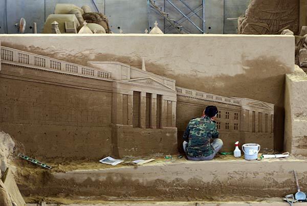 Jooheng Tan, a sculptor from Singapore, finishes a sand replica of Buckingham Palace.