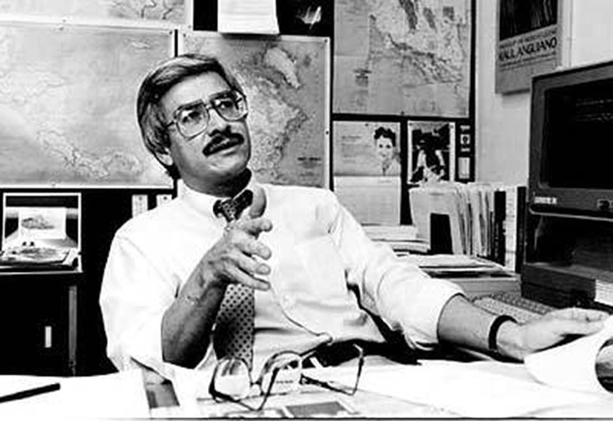 Frank del Olmo gestures while sitting at his desk in 1991