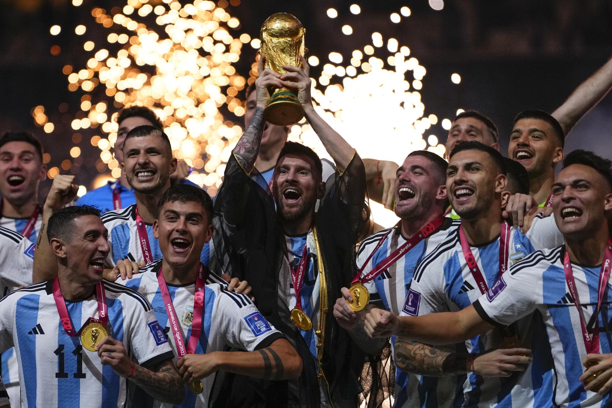 Argentina's Lionel Messi holds up the trophy after winning the World Cup final.