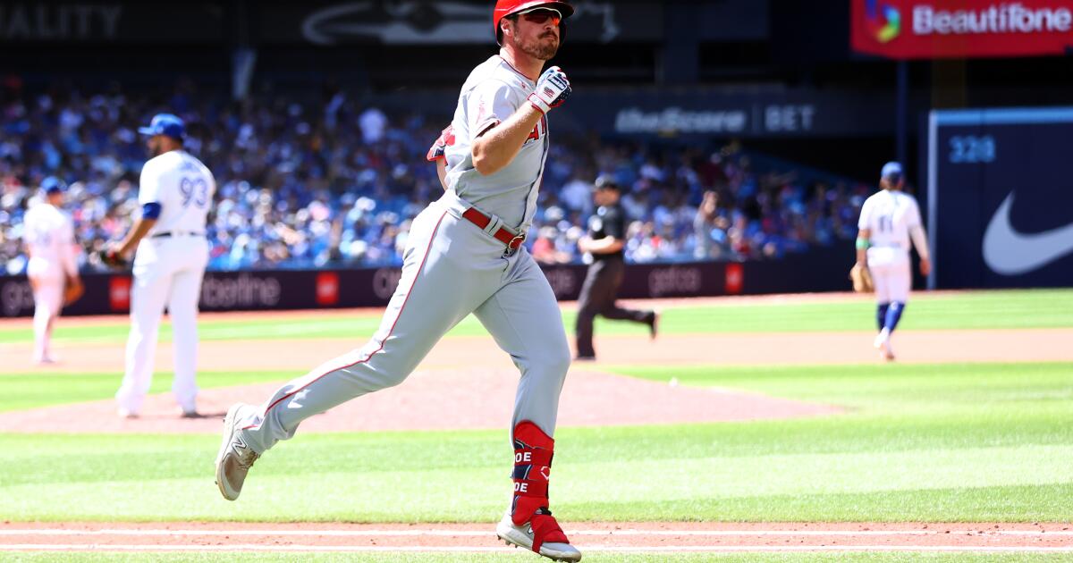 Los Angeles Angels' Mike Trout (27) gives Hunter Renfroe (12) a helmet  after Renfroe hit a home run during the eighth inning of a baseball game  against the Toronto Blue Jays in