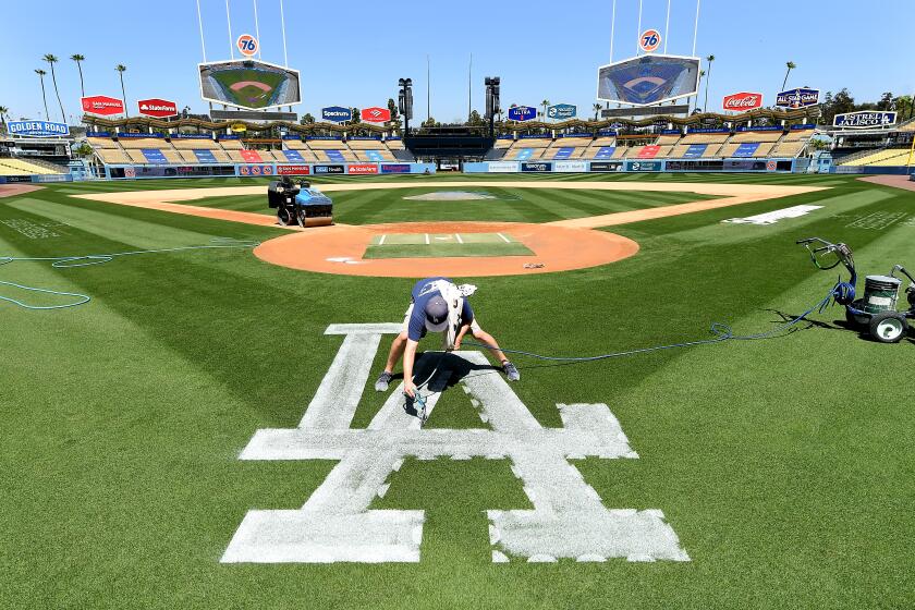 LOS ANGEL;ES, CALIFORNIA APRIL 8, 2021-Dodgers ground crew member Justin Patenaude paints the field.