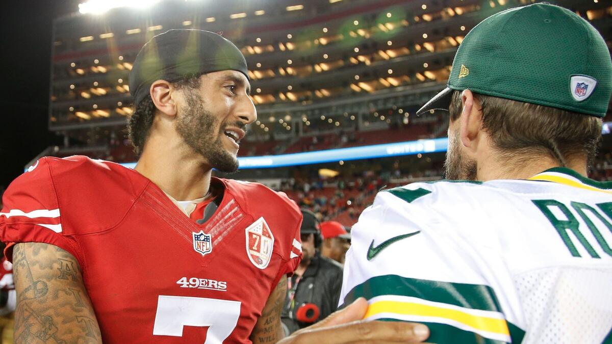 As a 49er in 2016, Colin Kaepernick, left, speaks with Green Bay's Aaron Rodgers following a preseason game.