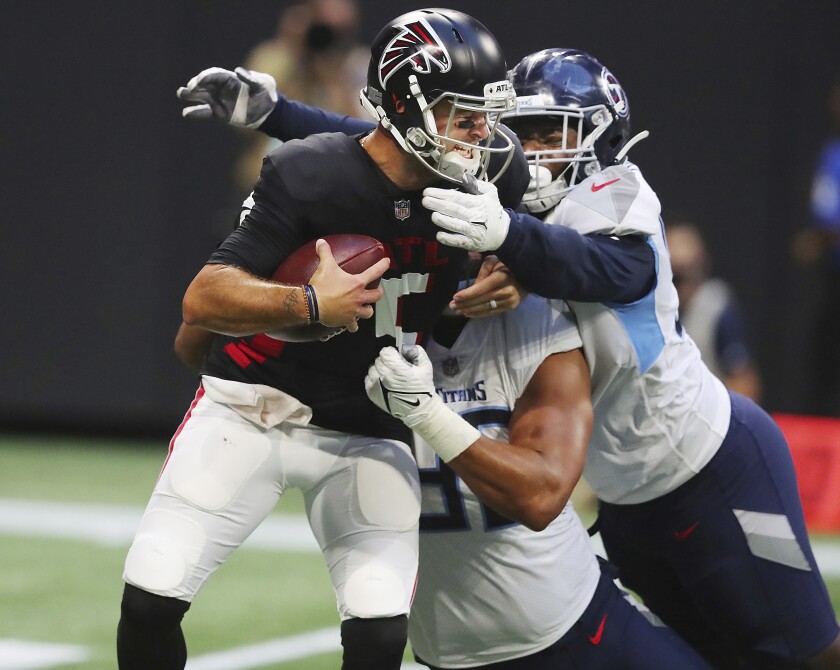 Atlanta Falcons quarterback AJ McCarron, left, is sacked by Tennessee Titans defensive tackle Trevon Coley and outside linebacker Rashad Weaver during the first half of an NFL football preseason game Friday, Aug. 13, 2021, in Atlanta. (Curtis Compton/Atlanta Journal-Constitution via AP)