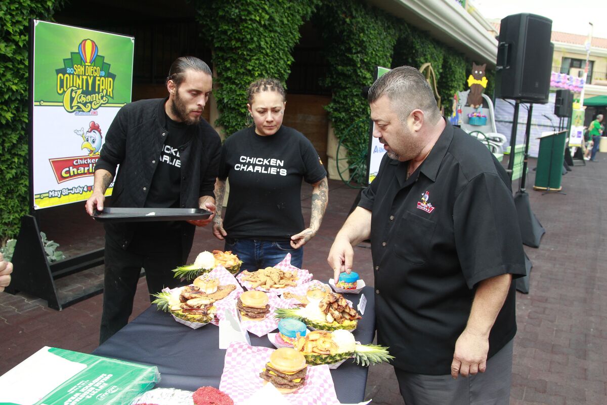Charlie Beghosian of Chicken Charlie's, right, talking to staff about new food item during the press preview for this year's "Wizard of Oz"-themed San Diego County Fair on May 14, 2019 in Del Mar.