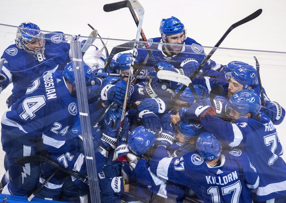 The Tampa Bay Lightning celebrate after Brayden Point (21) scored against the Columbus Blue Jackets during the fifth overtime in Game 1 of an NHL hockey Stanley Cup first-round playoff series, Tuesday, Aug. 11, 2020, in Toronto. (Frank Gunn/The Canadian Press via AP)