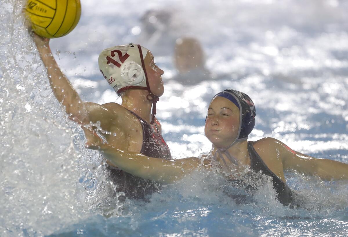 Ava Knepper (12) of Laguna Beach, side swims her defender and fires in her third goal against Newport Harbor.