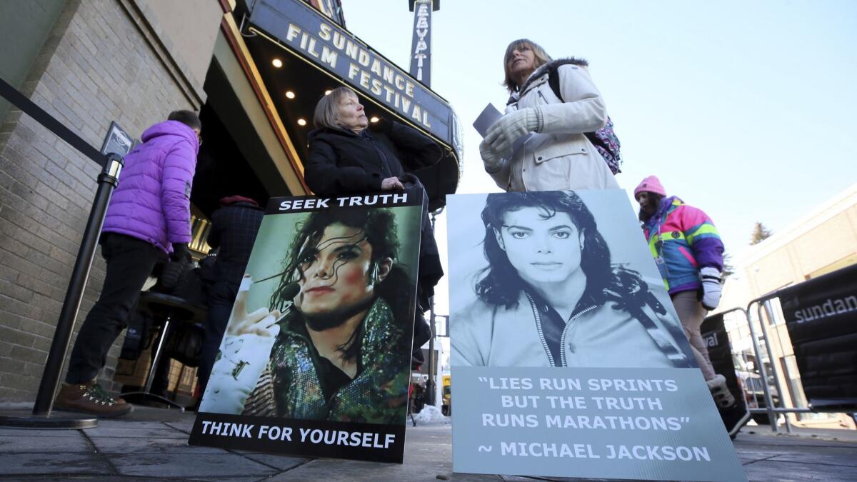 Brenda Jenkyns, left, and Catherine Van Tighem who drove from Calgary, Canada, stand with signs outside of the premiere of the "Leaving Neverland" at the Sundance Film Festival.