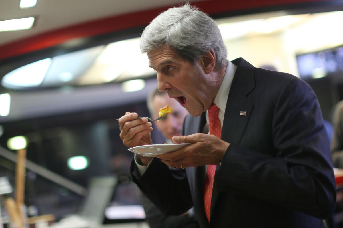 U.S. Secretary of State John Kerry eats sweets inside a shop after his meeting with Palestinian President Mahmoud Abbas in the West Bank city of Ramallah on Thursday.