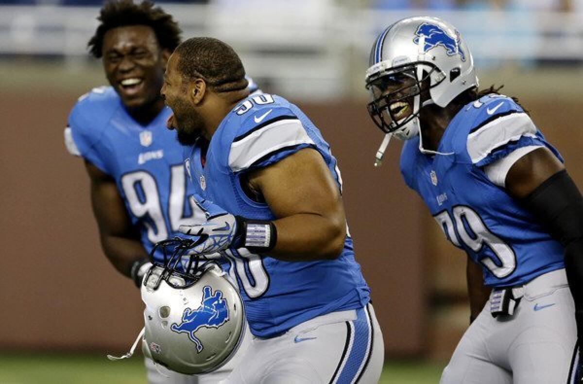 Detroit Lions defensive end Ezekiel Ansah (94), defensive tackle Ndamukong Suh (90) and defensive end Willie Young (79) share a laugh as they warm up for Sunday's game against the Vikings.