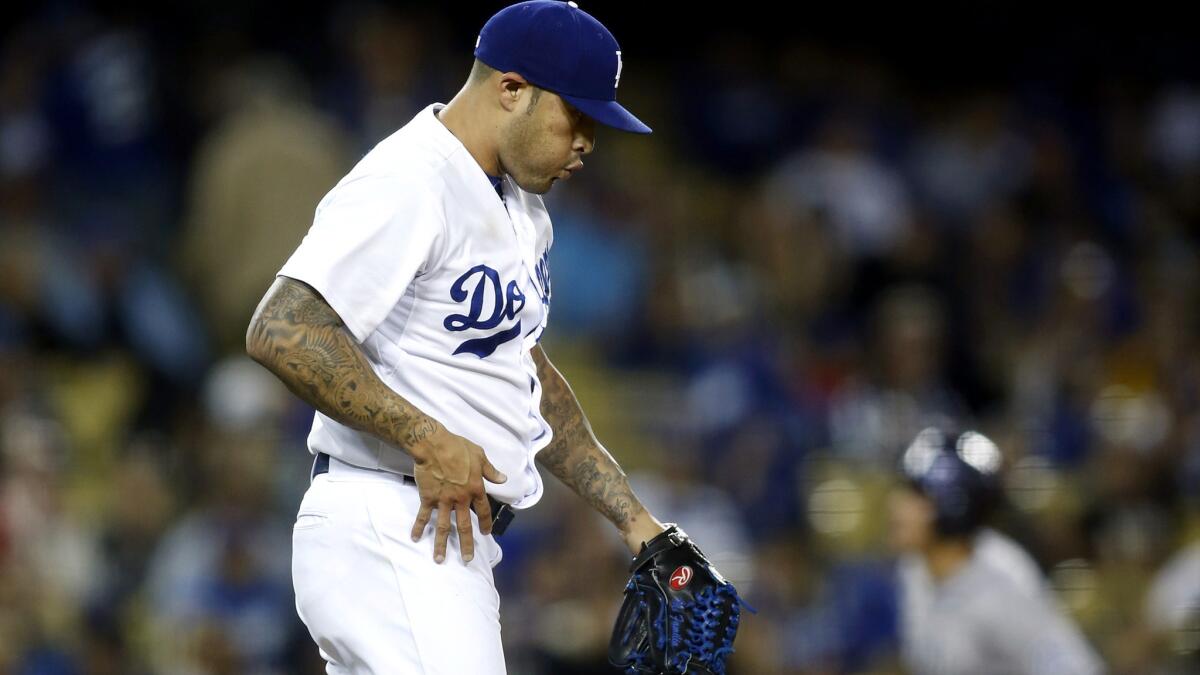 Dodgers reliever Sergio Santos reacts after Rockies third baseman Nolan Arenado (background) hit a two-run home run in the eighth inning Saturday night.