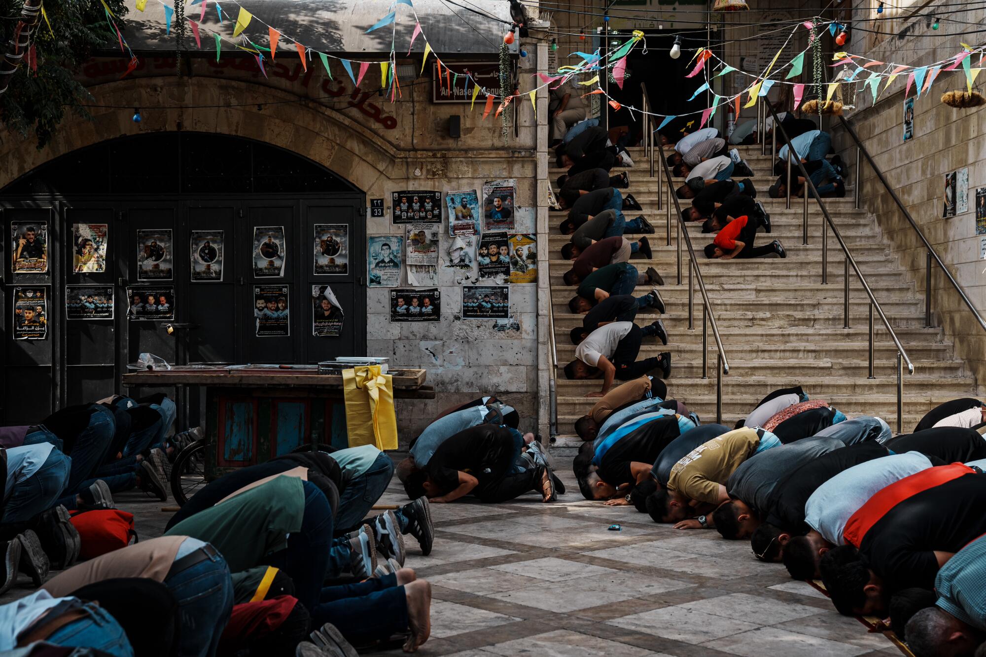 Local residents gather to hold Friday prayers outside the mosque inside the Old City of Nablus.