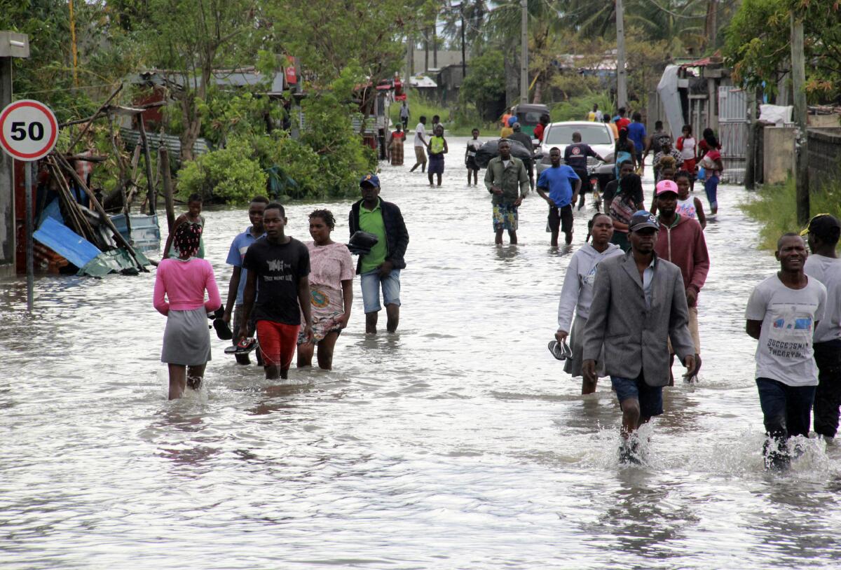 Personas caminan por calles inundadas en Beira, Mozambique, el sábado 23 de enero de 2021. 