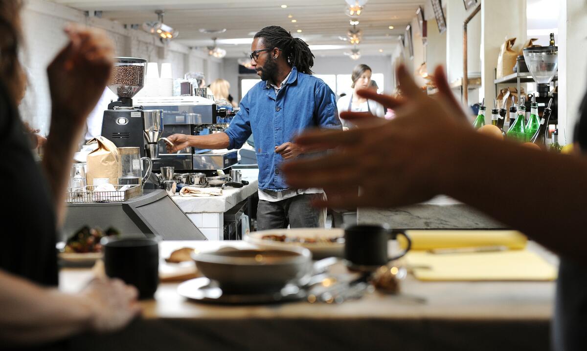 Barista Erik Rudo makes drinks as diners hang out, standing up, at Gjusta in Venice.