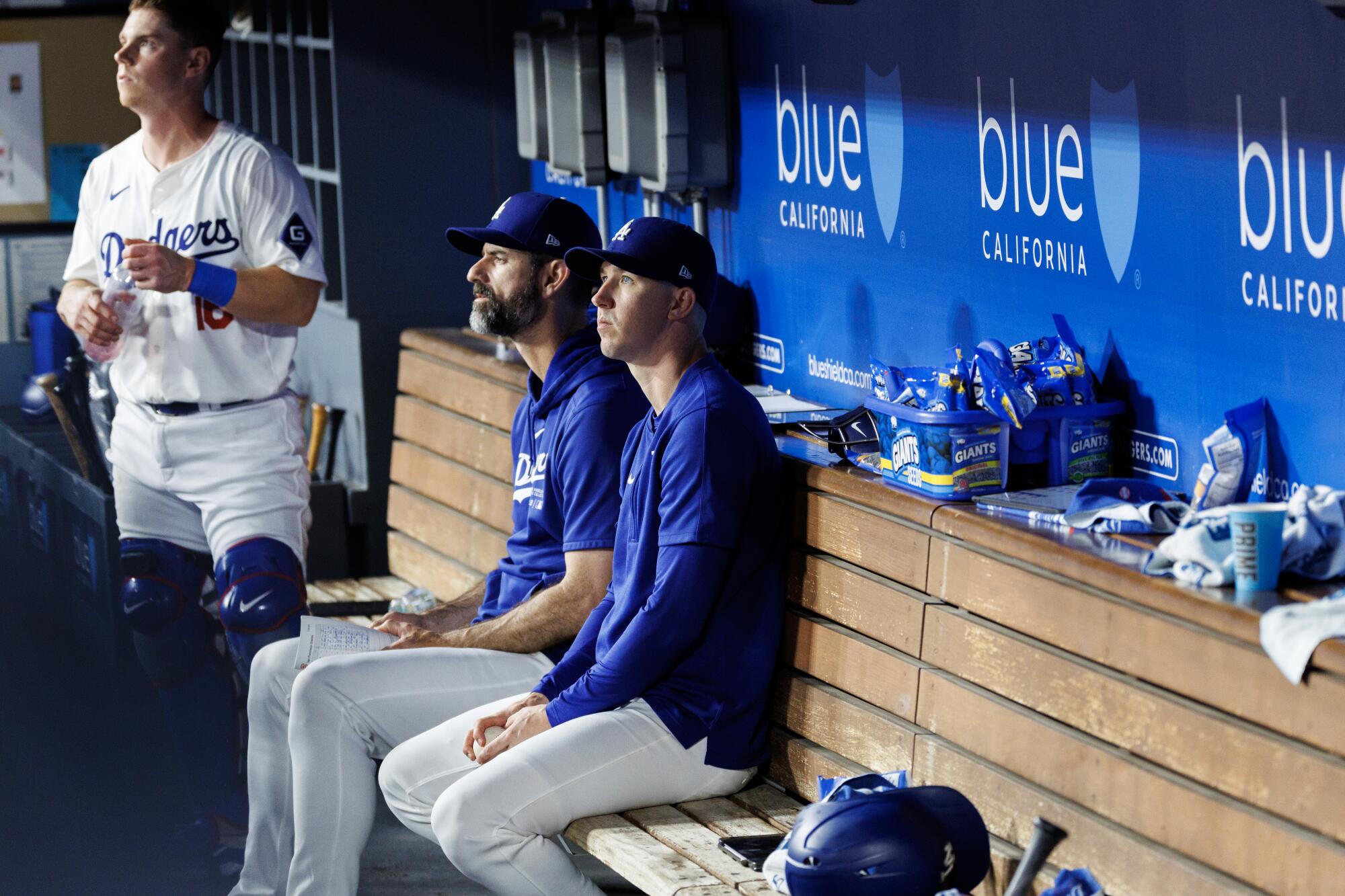 The Dodgers' Walker Buehler sits in the dugout next to pitching coach Mark Prior during Wednesday's game against the Giants.