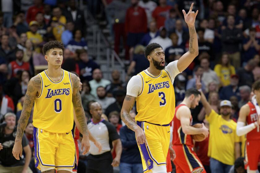Lakers forward Anthony Davis (3) celebrates alongside teammate Kyle Kuzma after making his final free throw to seal the Lakers' 114-110 defeat of the Pelicans on Nov. 27, 2019, in New Orleans.